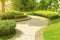 Landscape of smooth green grass lawn, trees with supporting, seating on gray curve pattern walkway sand washed finishing on