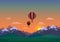 Landscape with snowy mountains, green meadows, spruce forest, colorful hot air balloons and clouds. Sunrise or sunset background.