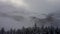 Landscape with snowy slopes, trees cloudy sky creating an atmospheric phenomenon
