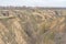 Landscape with soil erosion and flowering apricot trees in loamy ravines near Dnipro city, Ukraine