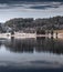 Landscape of a specular reflection in the lake, a dry grass, a cane and snags in the foreground, mountains and the