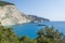 Landscape of steep rocky cliff, beautiful blue green sea and yacht