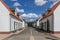 Landscape of straight cobbled street between houses with white walls and tiled gabled roofs in Dutch village