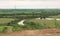 Landscape of sugarcane plantations with water reserves, electricity poles, roads and protective trees