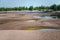 Landscape summer background of wild Sandy beach on river resort and green desert plant on horisont