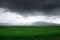 Landscape summer and spring. Bright green grass on the round hills. Clouds before the rain. Clouds in the sky. Tourism travel