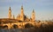 landscape of a sunrise on catholic basilica pilar in Zaragoza besides the Ebro river with some trees and plants at first site. The