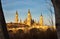 landscape of a sunrise on catholic basilica pilar in Zaragoza besides the Ebro river with some trees and plants at first site. The