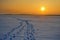 Landscape of sunset with smog, air pollution above frozen lake covered by snow.