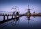 Landscape with traditional dutch windmills and drawbridge at sunrise