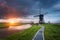 Landscape with traditional dutch windmills and path near the water canals.