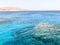 Landscape of transparent blue periling sea salt water, sea, ocean with waves with a bottom of beautiful coral reefs, stones agains