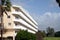 Landscape in tropical area resort hotel building around palms trees in countryside with grass and mountains on horizon