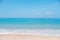 Landscape of tropical beach in summer. Sandy beach with sea waves and blue sky background.