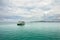 Landscape with turquoise tropical sea, cargo ferry, scenic clouds and tropical Koh Chang island on horizon in Thailand