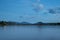 Landscape of Uttamanusorn Bridge or Mon Bridge with reflection on river and blue sky at Kanchanaburi province, Thailand.