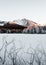 Landscape vertical photo of frozen and snow covered Strba tarn Strbske pleso in winter time. Mountains in Slovakia with frozen