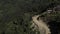 A landscape view from above of nepalese forest. Sand road with cars.