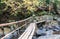 Landscape view of bamboo bridge across water stream, with cauti