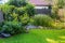 Landscape view of  beautiful garden with freshly mowed lawn and robotic lawn mower