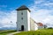 Landscape view of the church of the Bessastadir, a modest group of white, red-roofed buildings