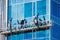 A landscape view of construction workers high in the sky doing repairs