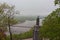 Landscape view of  Dnipro River with the Pedestrian Bridge and famous Monument  of Vladimir The Great during spring foggy morning