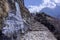 Landscape view of everest base camp trekking path with few alpinist going up. Path leading to the top with some trees around and