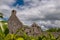 A landscape view through through foliage of the abanoned ruins of Killone Abbey that was built in 1190 and sits on the banks of