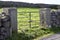 Landscape view of a gate and stone wall on the rugged terrain of Inishmore island in Ireland