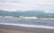Landscape view of gentle waves rolling in on Raumati Beach, New Zealand