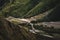 Landscape view of the gorge at the bottom of which the river flows and the road passes. Anti-avalanche pyramids in