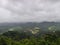 A landscape view of green hills with cloudy sky on the background in Coorg, India