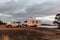 Landscape view of a large white caravan and modern 4WD vehicle free camp at sunrise next to the nearly dry salt Lake Norring which