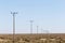 Landscape view of many power poles in a row