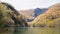 Landscape view of mountain, leaves changing color and lake at Kamikochi National Park with tourist bus.