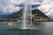 Landscape with a view of the mountains, a boat on Lake Lugano, with a fountain and a rainbow, in Lugano, Switzerland