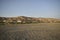 Landscape view of oman roads. A landscape made of rocks, gravel and acacias,buildings with mountain in the background. Muscat, Oma