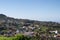 Landscape view over a green hill full of tiny white and orange houses