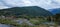 Landscape view over Lim river, with a swamp near houses, forested mountain and cloudy sky background