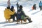 Landscape view of a snowy hill with families with children and people sledging and having fun in snow, Park Maksimir in Zagreb