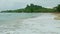 landscape view of strong white waves of blue ocean run on golden sandy beach