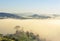 Landscape view of sunrise with white fog in early morning covered on the top of the hill