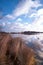 Landscape view at sunset, water reflection, large nature reserve with a lake, white clouds and blue sky. Fochteloerveen