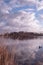 Landscape view at sunset, water reflection, large nature reserve with a lake, white clouds and blue sky. Fochteloerveen