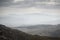 Landscape view from top of mountain on misty morning across countryside with fading layers