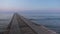 Landscape view of tranquil sunrise on the sea with wooden pier Looping