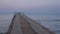 Landscape view of tranquil sunrise on the sea with wooden pier looping