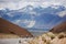 Landscape view with two cyclists riding to snowy mountain range background