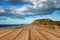 Landscape vivd sunset over beach and cliffs with wooden planks f